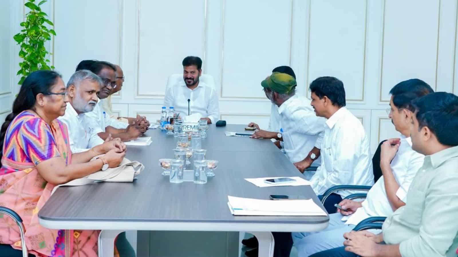 Business meeting with diverse professionals around a conference table in a modern office setting.