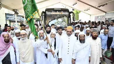 The Siasat Daily: Religious leaders and community members gather around a tractor at a public event.
