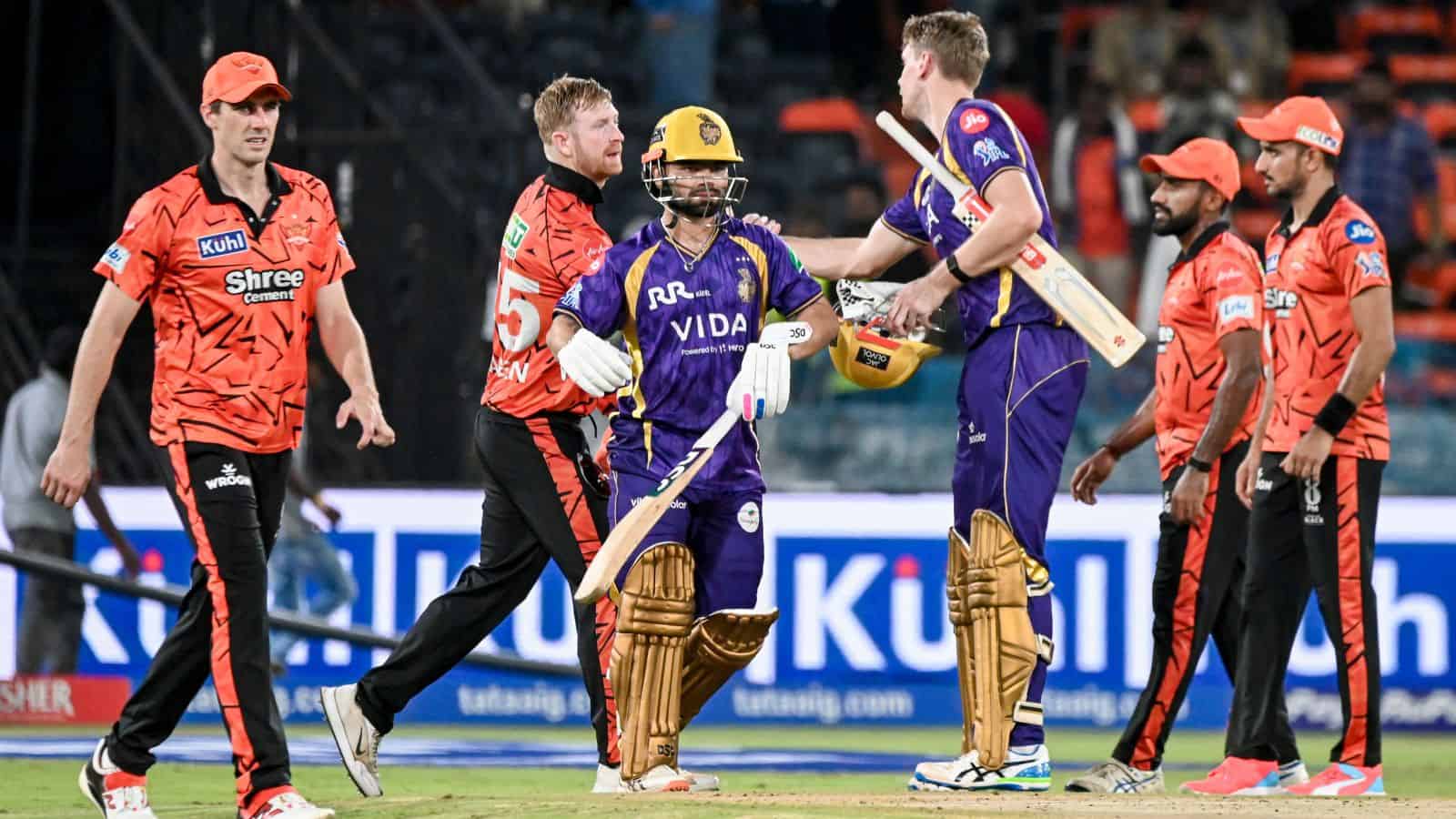 Cricket players celebrating after a match, with team members and officials in a stadium setting.