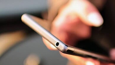 Person holding a smartphone with a buzzing notification for NDMA alert test.