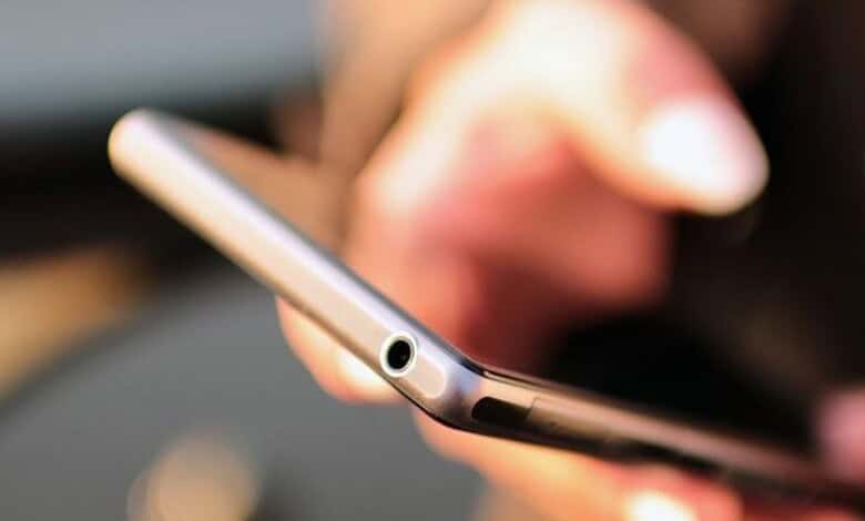 Person holding a smartphone with a buzzing notification for NDMA alert test.
