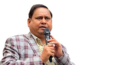 Man speaking into microphone during election rally, Assam assembly election results 2023, NDA majority.