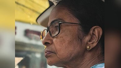 Close-up of an elderly woman in a vehicle, reflecting on the Bengal assembly election results and the BJP.