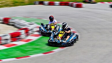 Two young drivers racing go-karts on a track in Hyderabad, capturing a competitive moment.