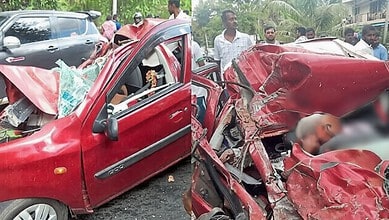 A woman and a child injured in a severe car accident with a heavily damaged red vehicle. Bystanders gathe.