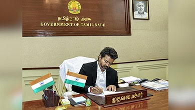 Indian government official signing documents at Tamil Nadu government office, promoting new schemes for p.