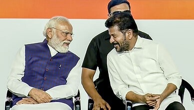 Indian Prime Minister Narendra Modi smiling and engaging with Telangana Chief Minister Revanth Reddy duri.