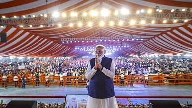 Prime Minister Narendra Modi at Parade Grounds in Telangana, delivering a bold speech with a large crowd.