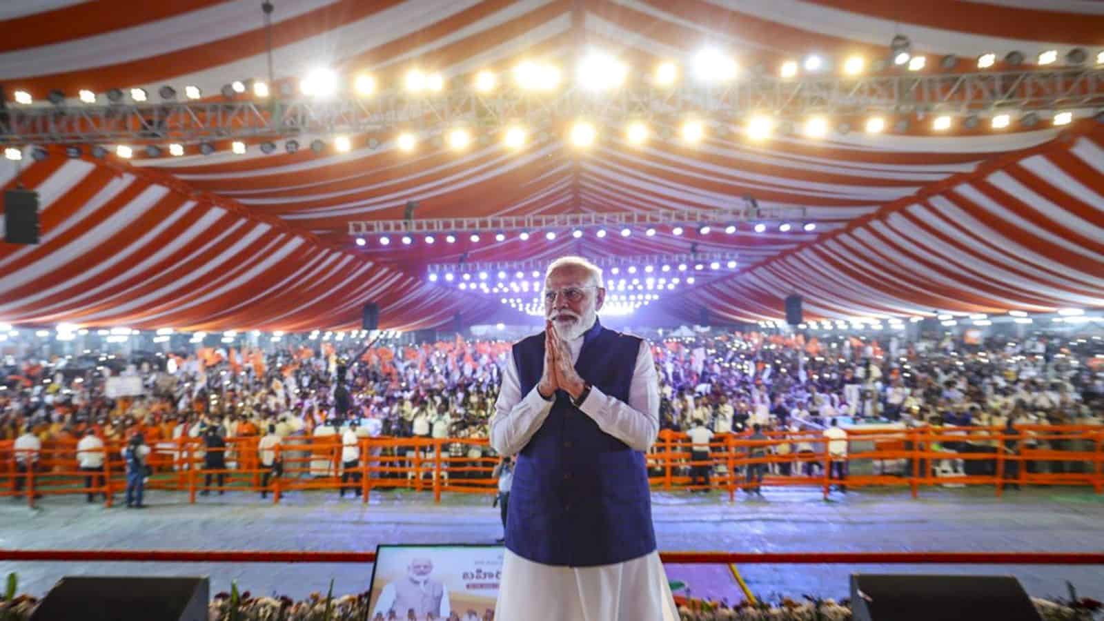 Prime Minister Narendra Modi at Parade Grounds in Telangana, delivering a bold speech with a large crowd.