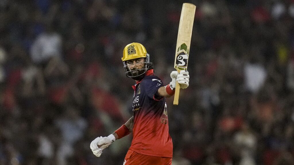 RCB cricketer celebrating after winning last-ball IPL match against MI with a bat in hand.