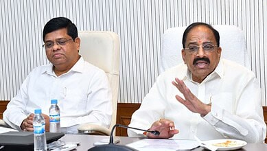 Minister speaking during a meeting about urea allocation for Telangana farmers, with officials present.