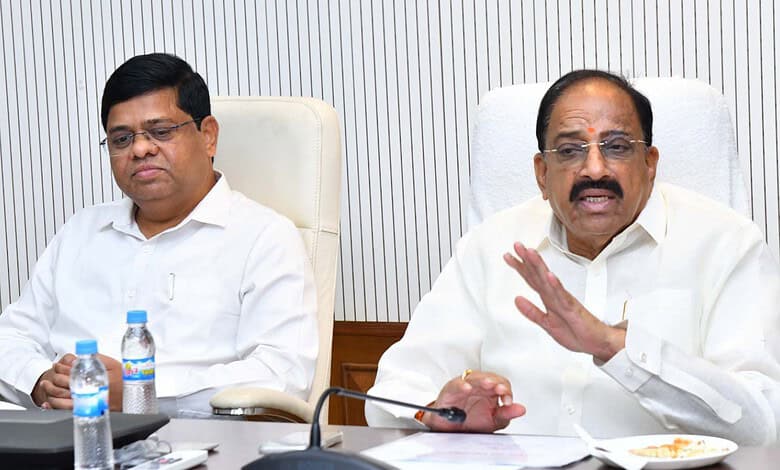 Minister speaking during a meeting about urea allocation for Telangana farmers, with officials present.