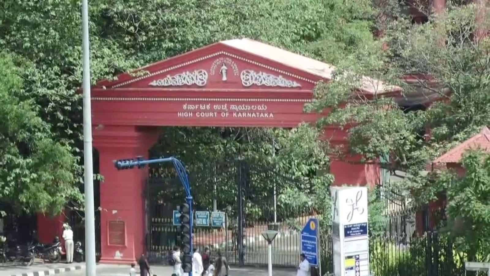 High Court of Karnataka entrance gate in Bangalore, surrounded by greenery and official signage.