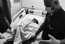 A young boy lying in hospital bed after dog attack in Hyderabad, with medical staff attending to him.