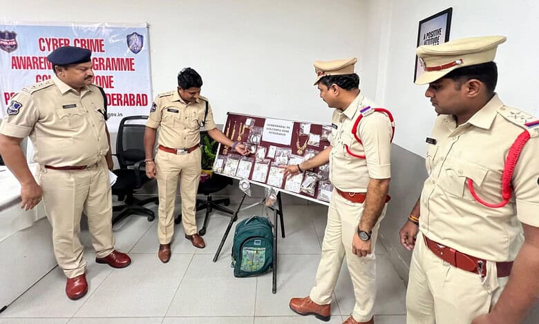 A man in police uniform with officers examining evidence related to burglary case in Hyderabad.