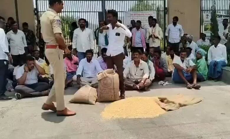 A man in white shirt and brown pants selling grains to a group of people sitting outside, with a police o.