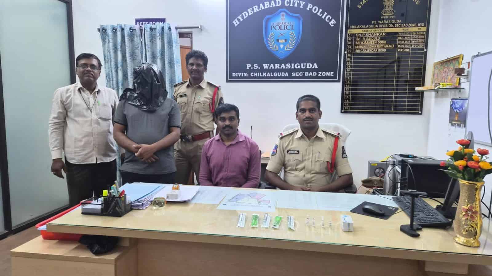 Police officers and staff members seated and standing in Hyderabad City Police office, Hyderabad, Telanga.