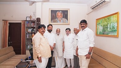 Celebrating Indian leaders in a modern office setting with a portrait of Narendra Modi in the background.