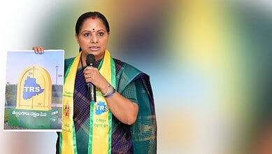 Empowered woman politician holding a TRS poster during a public event in Telangana, India.