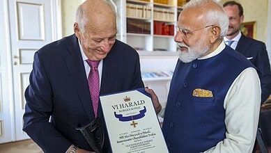 Honourable elderly man receiving award from Indian Prime Minister Narendra Modi at a formal event in Indi.