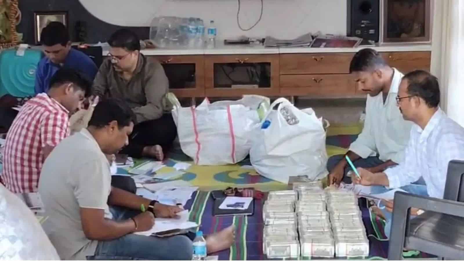 ACB officials count cash seized from the general manager's house