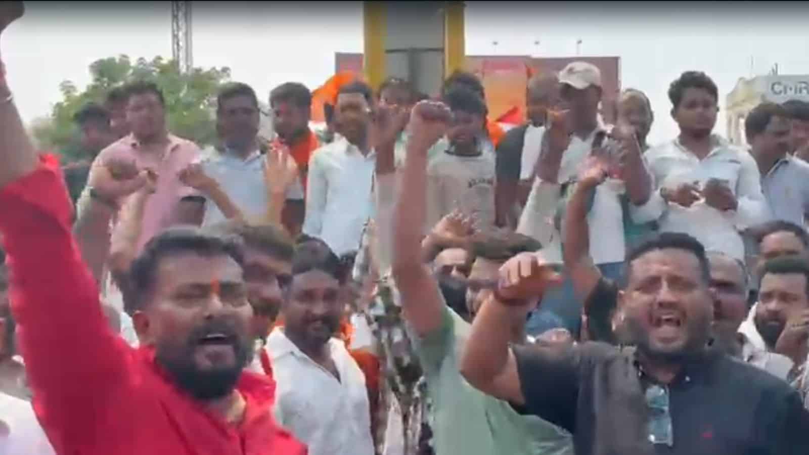 Protesters protesting passionately with raised fists and shouting during a demonstration in an urban area.