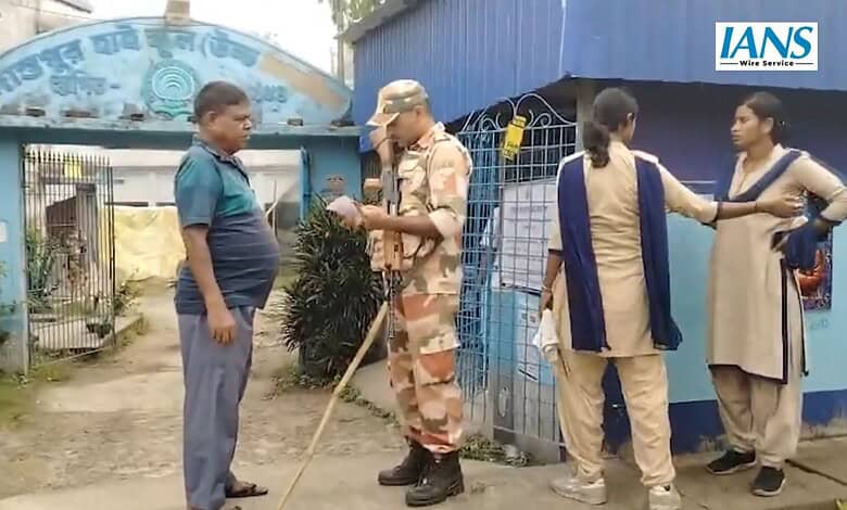 Security guard checks a voter's slip in West Bengal