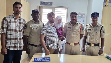 Group of police officers and civilians posing together in an office setting.