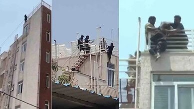 A woman and a man on a rooftop, with others assisting, in an urban setting during daytime.