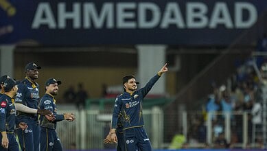 A cricket player from Gujarat Titans celebrating after a successful match at Ahmedabad stadium.
