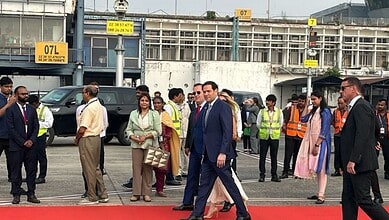 Business professionals and security personnel at an airport terminal, with officials and staff in formal.