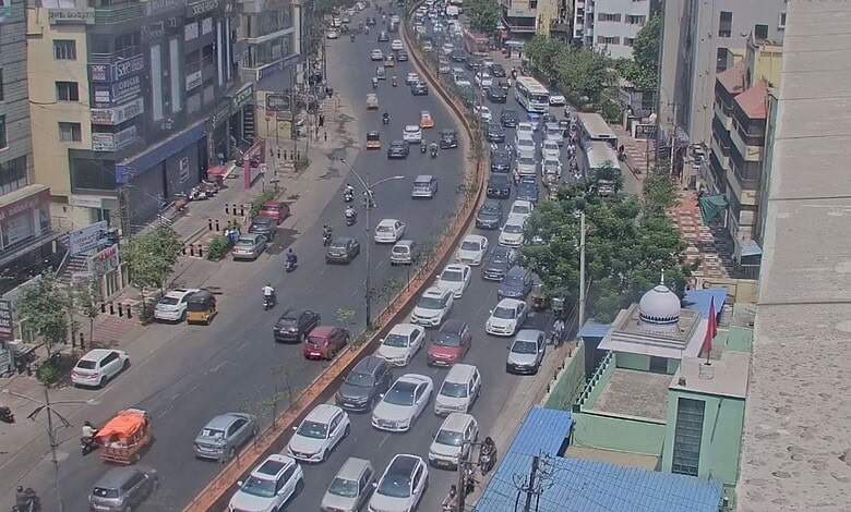 A busy urban street with heavy traffic and tall buildings in a cityscape.