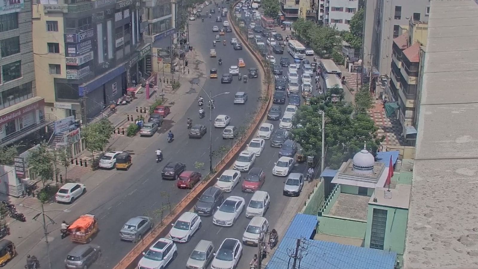 A busy urban street with heavy traffic and tall buildings in a cityscape.