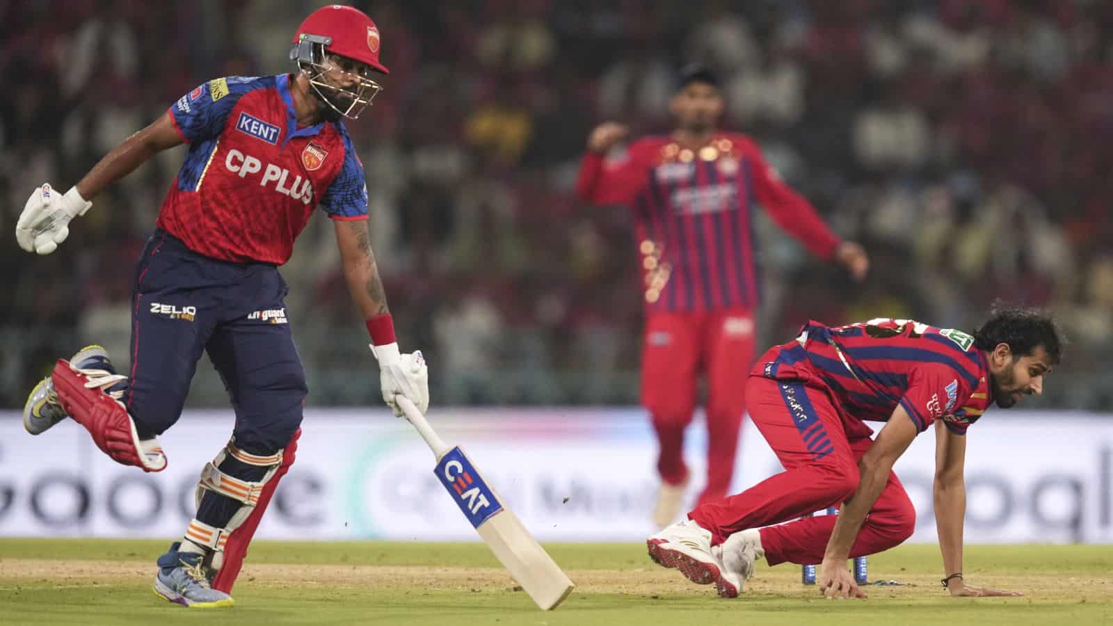 A cricket player in red and blue uniform running on the field during a match.