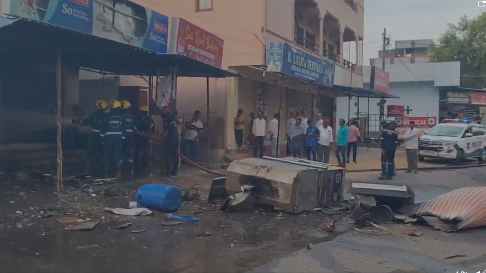 A woman injured in a fire accident at a busy commercial area in Hyderabad, with emergency responders and.