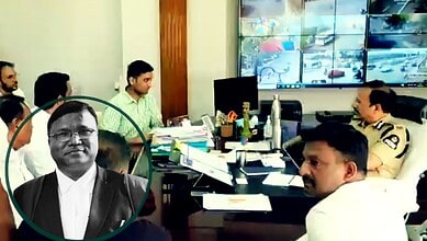 Police officers and officials in a meeting room with multiple screens displaying traffic footage.