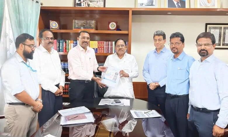 Senior officials and executives in a formal meeting exchanging documents in an office setting.