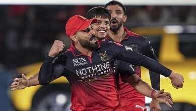 A vibrant cricket team celebrating a successful play on the field during a match.