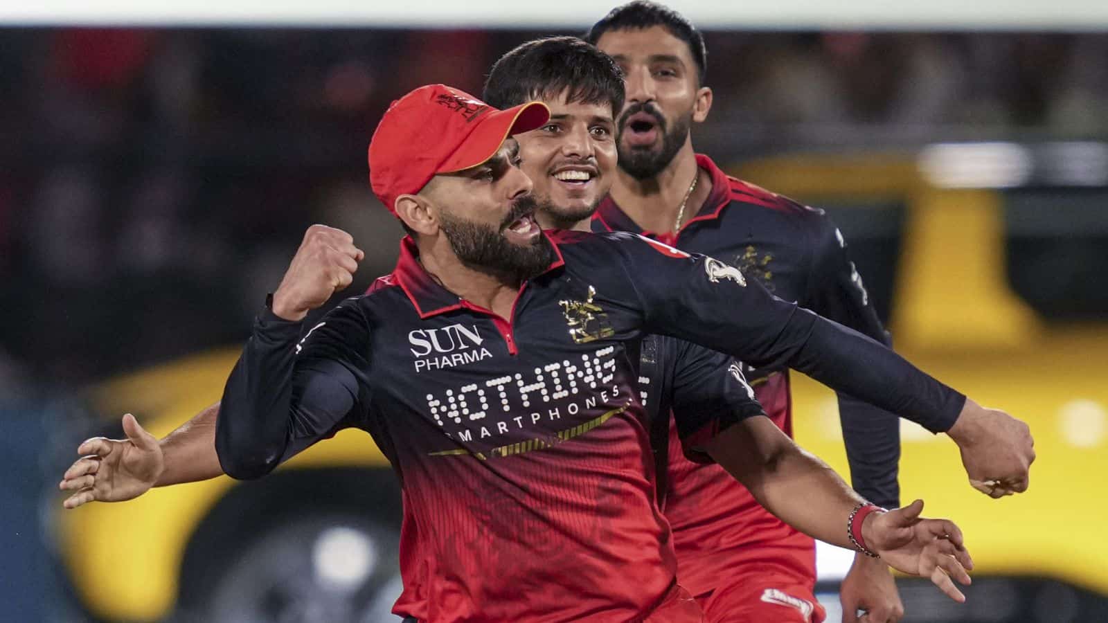 A vibrant cricket team celebrating a successful play on the field during a match.