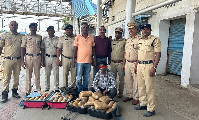 A man with a face mask surrounded by police officers displaying seized packages on the street.