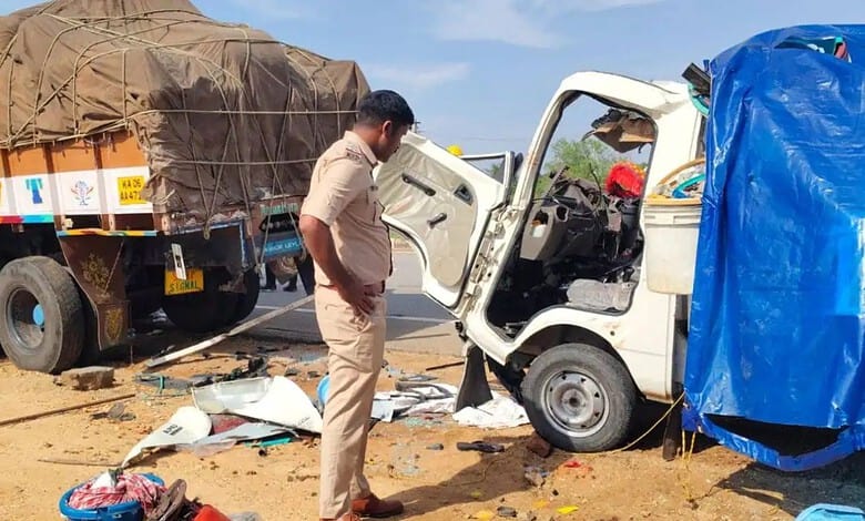 A man inspecting a small white truck involved in a road accident with debris scattered around.