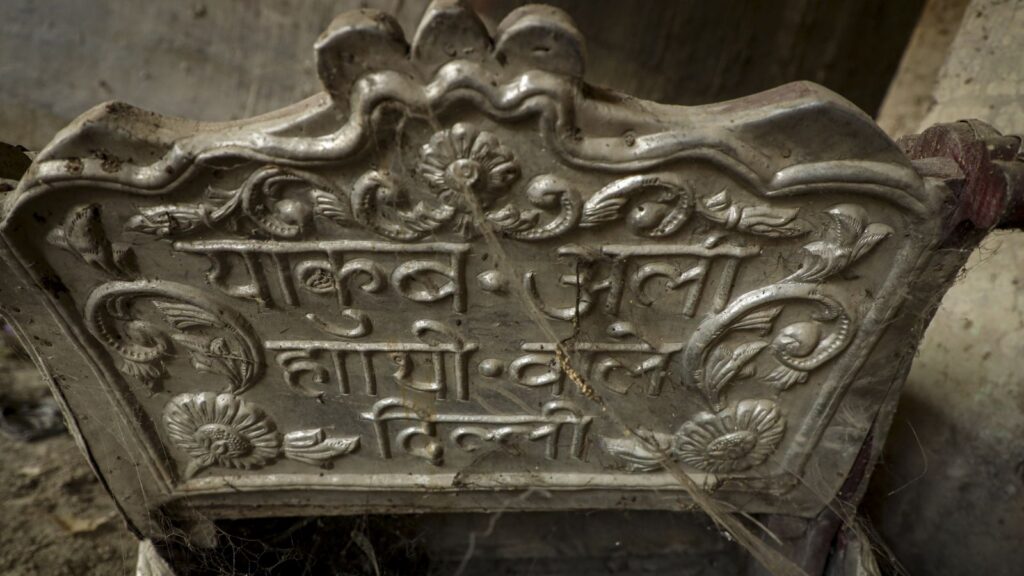 Ancient stone inscription with intricate carvings and Hindi script, showcasing historical craftsmanship a.
