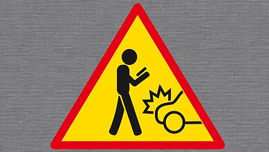 Caution sign warning of a falling object or hazard with a person and an impact symbol.