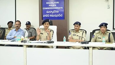 Police officers and officials seated at a conference table during a meeting at Malkajgiri Police Commissi.