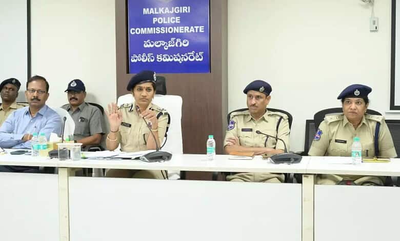 Police officers and officials seated at a conference table during a meeting at Malkajgiri Police Commissi.