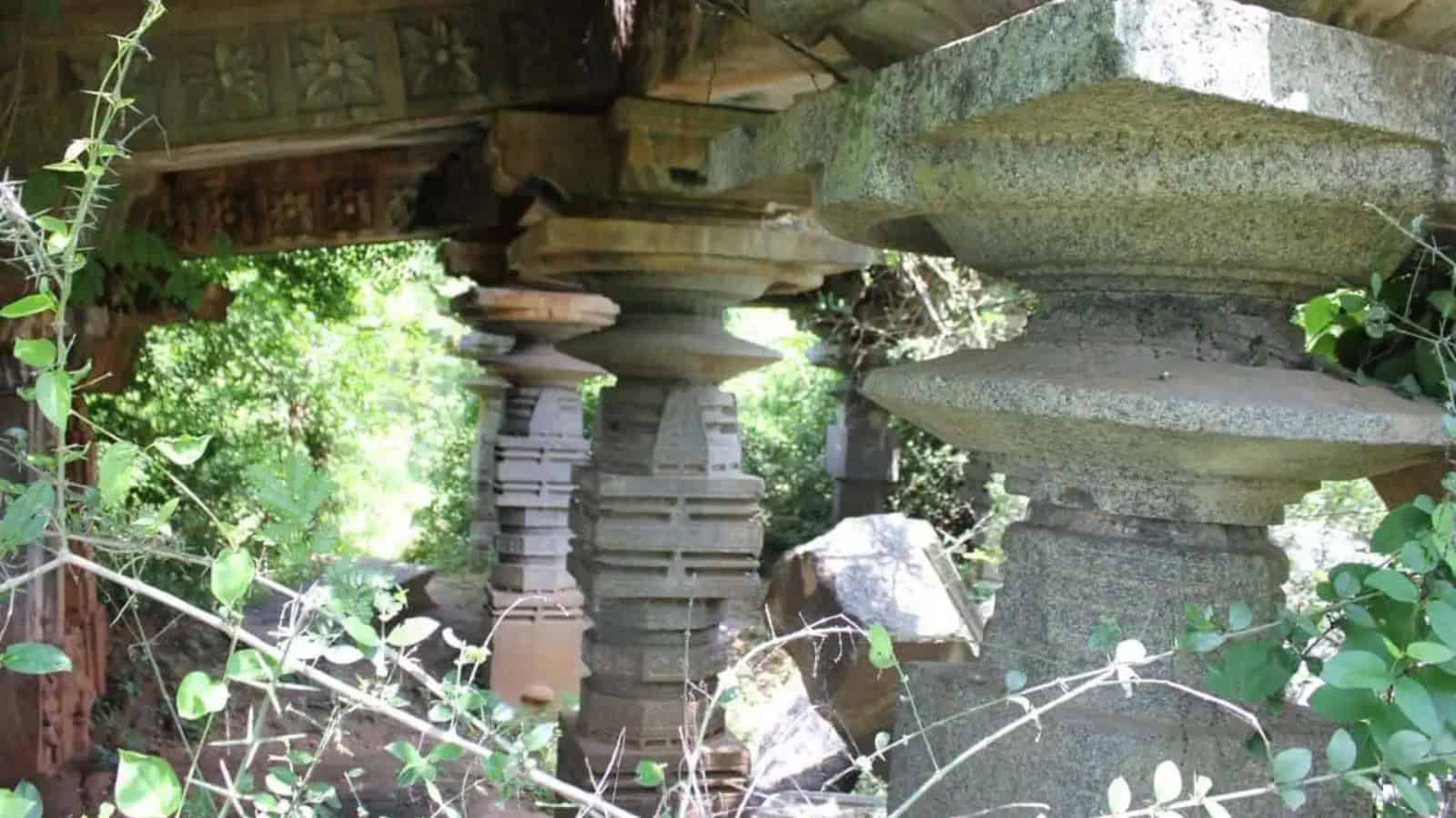 Ancient Kakatiya-era Warangal temple ruins with stone pillars and lush greenery, highlighting historical.