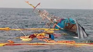 A sinking fishing boat off Goa coast with 22 fishermen rescued in the background.