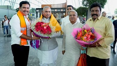 BJP leader with floral bouquets welcoming political leaders at an outdoor event in India.