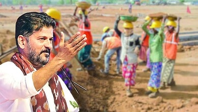Politician speaking to workers at a construction site with a group of women in safety helmets in the back.