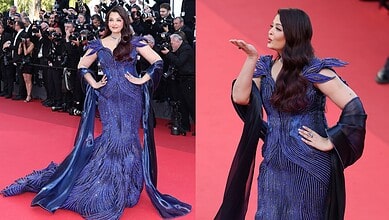 A woman in a stunning blue evening gown on the red carpet at a formal event.